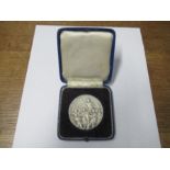 A silver medal, from the 1948 London Olympic Games, after a design by Giuseppe Cassiolo, in a blue