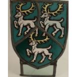 An Antique stained glass panel, of shield form, decorated with three stags, rectangular panel below,