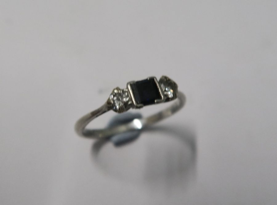 A sapphire and diamond three stone ring, stamped 'Plat', the rectangular cut sapphire flanked either