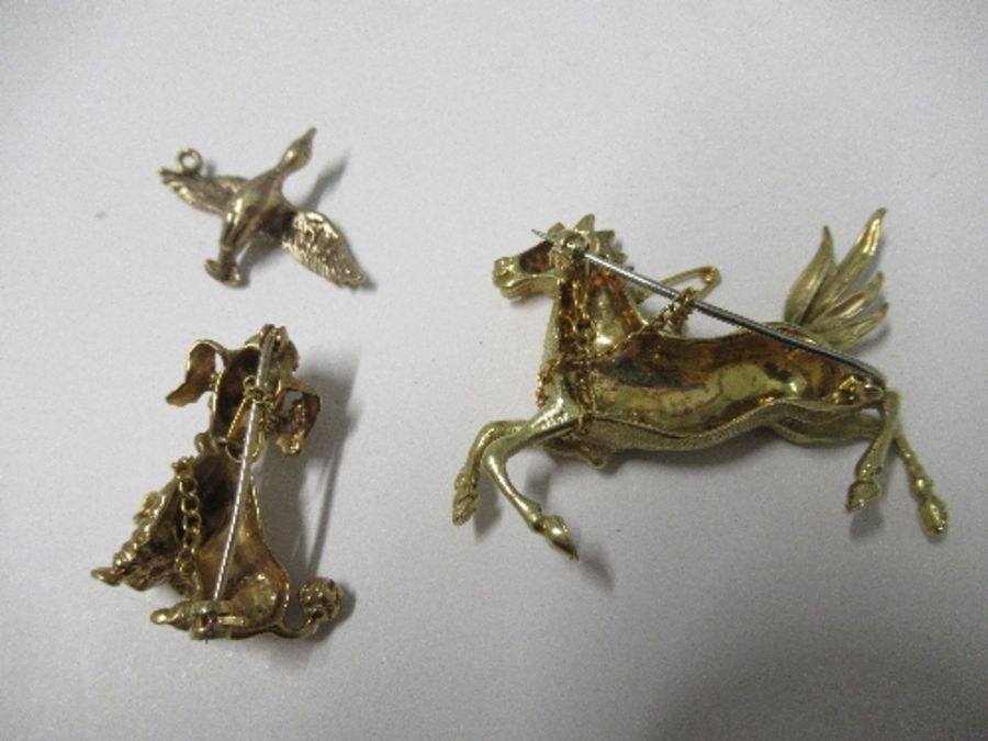 A yellow metal horse brooch, a 9ct gold duck pendant, and a 9ct gold poodle brooch, 27g gross - Image 2 of 2