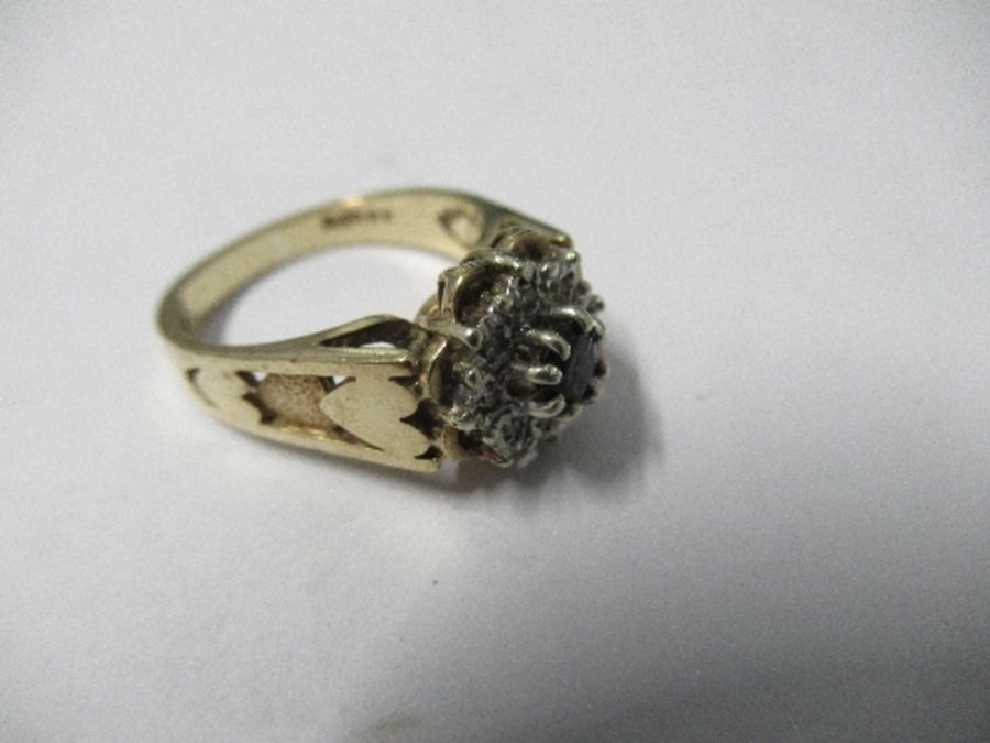 A 9 carat gold sapphire and diamond cluster ring, the round cut stone enclosed by single cuts, - Image 2 of 4