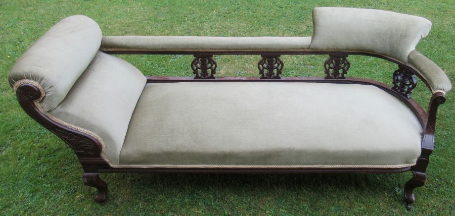 A late 19th century mahogany and upholstered chaise longue, with pierced carved uprights, raised