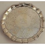 An 18th century silver card tray, with shell ogee border, engraved band and crest to the centre,