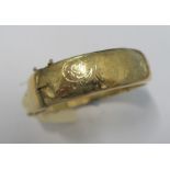 A 9 carat gold half engraved hinged bangle, Chester 1960, approximately 18mm wide, 24.9g gross
