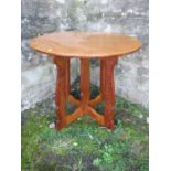 An Arts & Crafts oak Hispanic style circular lamp table, in the style of Sir Peter Lorimer, with