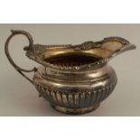 A silver cream jug, with gilt wash interior, gadrooned and shell edge, with gadrooned lower body,