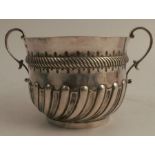 A Mappin and Webb silver two handled cup, with wrythern gadrooned lower body and a pair of scroll