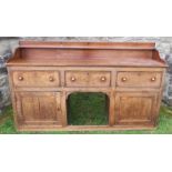 An antique oak Welsh sideboard, with three drawers to the frieze, above cupboard doors to each side,