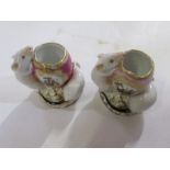 A pair of small vases, formed as two mice looking into a broken egg, the eggs decorated with