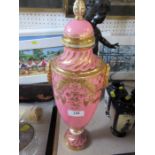 A Minton porcelain covered vase, decorated in gilt to a pink ground, with gold wreath handles, on
