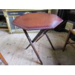 An octagonal top folding table, raised on turned legs, height 23ins x diameter 22ins