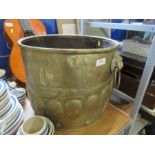 An Arts and Crafts style brass log bin, of circular form, embossed with a Viking style boat,