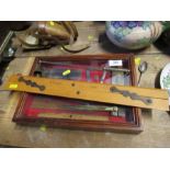 A mahogany and glass display case, containing various brass, steel and wood tools, together with