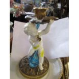 A Moore porcelain candlestick, formed as a putti riding a sea serpent holding a lily pad, af, height