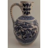 An early 20th century delft pottery jug, decorated in blue and white with flowers, marks to base