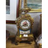 A gilt metal and porcelain mantel clock, the porcelain panels decorated with cherubs and flowers,