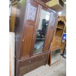An Edwardian mirror door wardrobe, with carved decoration and drawers to the base, width 49ins,