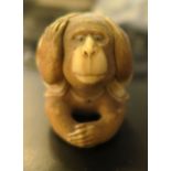 A small netsuke of a seated monkey - There is a chip to the base of the shirt and it is generally