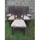 A set of six oak dining chairs, with carved decoration, and carved face to the central splat