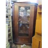 A large Edwardian free standing glazed corner cabinet, with cross banded decoration, the glazed door