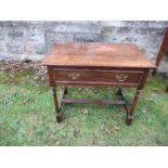 An antique oak side table, with frieze drawer, raised on turned legs united by a stretcher, width