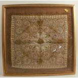 A framed embroidered square panel, decorated in gold thread with flowers to a cream silk ground,