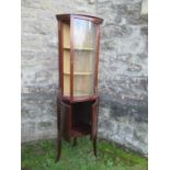 A free standing corner cupboard, the glazed upper section opening to reveal shelves, over cupboard