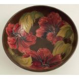 A Moorcroft Pottery bowl, decorated in the Hibiscus pattern to a brown ground, diameter 6.25ins,