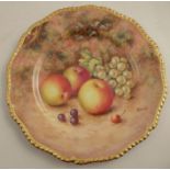 A Royal Worcester cabinet plate, decorated with fruit to a mossy background by Freeman, with