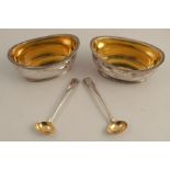 A pair of Georgian silver oval salts, with gadrooned edge and gilt wash interior, engraved with a
