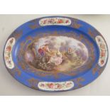 A Sevres oval blue ground serving dish, decorated with figures and a flower basket in a landscape,