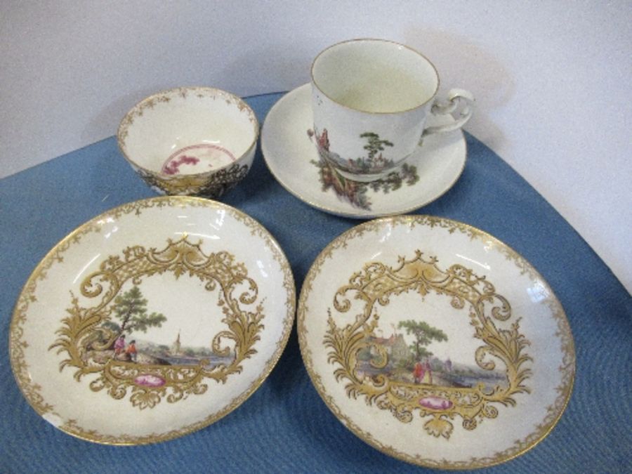 An 18th century coffee can and saucer, decorated in colours with figures in a landscape, together