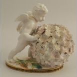 A 19th century Moore porcelain centre piece, formed as a cherub pushing a flower ball, on an oval