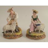 A pair of continental figures, of a man and woman seated with sheep, af, both height 5ins