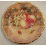 A Royal Worcester cabinet plate, decorated with fruit to a mossy background by Higgins, with