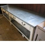 An Antique painted pine work bench, with metal cover to the top and under shelf, fitted with five