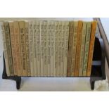 A mahogany and satinwood book trough, width 11ins, together with twenty-three Beatrix Potter books