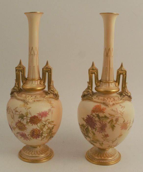 A pair of Royal Worcester blush ivory vases, decorated with flowers, on a pedestal foot, shape