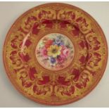 A Royal Worcester cabinet plate, decorated with flowers to the centre by Freeman, with burgundy