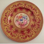 A Royal Worcester cabinet plate, decorated with flowers to the centre by Freeman, with burgundy