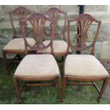 A set of four reproduction mahogany dining chairs, with carved shield backs and drop in seats