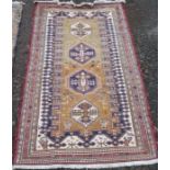 A Kelim style rug, decorated with four hooked to a gold ground, 75ins x 48ins