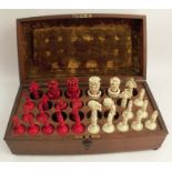 A 19th century carved ivory chess set, stained red and natural, highly carved with leaves, height of