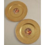 Two Royal Worcester plates, decorated with central panels of fruit by Reed, to an acid etched gilt