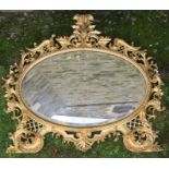A gilt frame oval wall mirror, the frame decorated with scrolls and lattice, overall dimensions