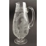 A glass jug, decorated with Classical figures, height 11ins