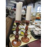 A pair of carved wooden candle stands