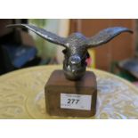 A desmo car mascot, of an eagle perched on a ball, possibly Alvis, on a wooden base, height 4.25ins