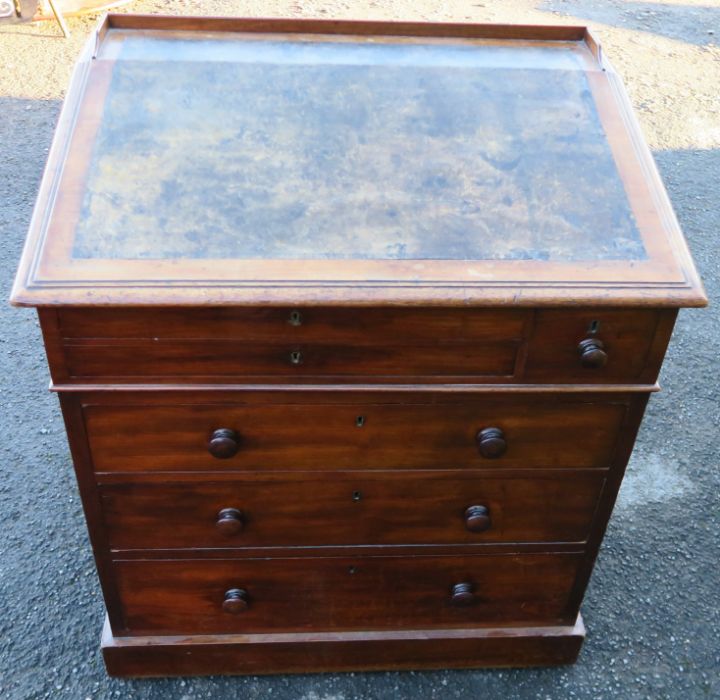 A 19th century mahogany desk, with sloping writing surface, over six drawers, raised on a plinth