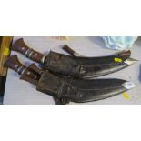 Two Kukri knives, with wooden and metal handles and leather scabbards